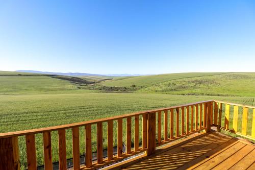 a wooden deck with a view of a green field at Rolling Hills Farmstead in Caledon