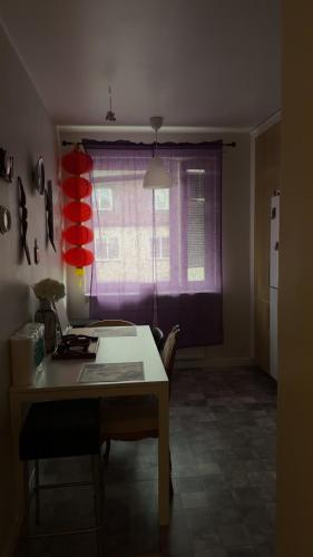 a kitchen with a table and a purple window at Farostrand in Klintehamn