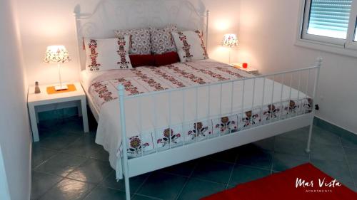a bedroom with a bed with a white bed frame and two lamps at Mar Vista in Primošten