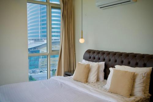 ein Schlafzimmer mit einem Bett und einem großen Fenster in der Unterkunft Cloud 9 Condos Elysium Tower in Islamabad