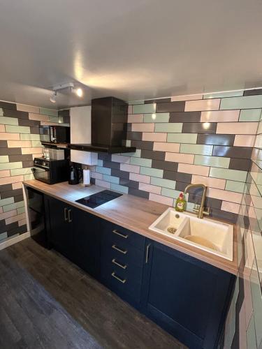 a kitchen with a sink and a counter top at Hill Street Railway retreat. in Elsecar