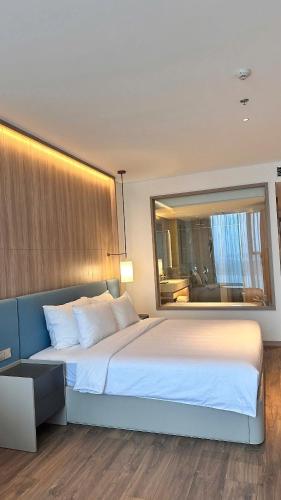 a bedroom with a large bed with a large mirror at Happy home happy sunrise and sunset in Ha Long