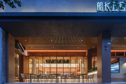a group of tables and chairs in a building at 船长五号青年酒店-上海中山公园江苏路地铁站店 in Shanghai