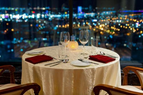 a table with a white table cloth and wine glasses at Four Points by Sheraton Danang in Da Nang