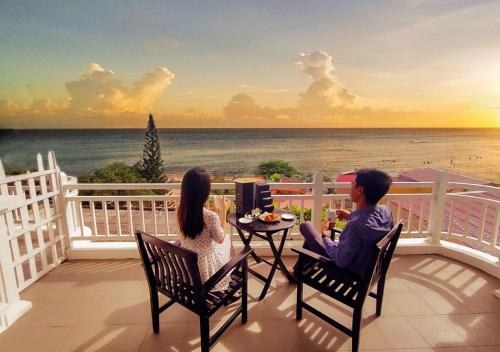 een man en vrouw op een balkon met uitzicht op de oceaan bij SV Boutique Resort in Vung Tau