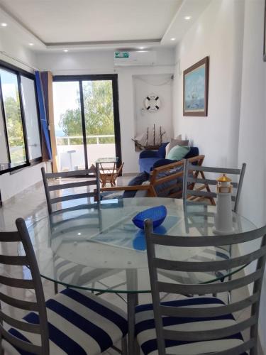 a dining room with a glass table and chairs at Amiral in Tabarka