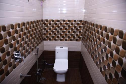a bathroom with a white toilet in a room at Hotel L S Restaurant And Spa in Nāi