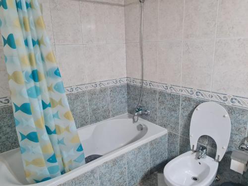 a bathroom with a tub and a sink and a mirror at Geovanny house in Funchal