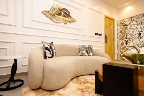 a living room with a couch and a table at Luxe Beachfront Apartment Lagos in Okunaja