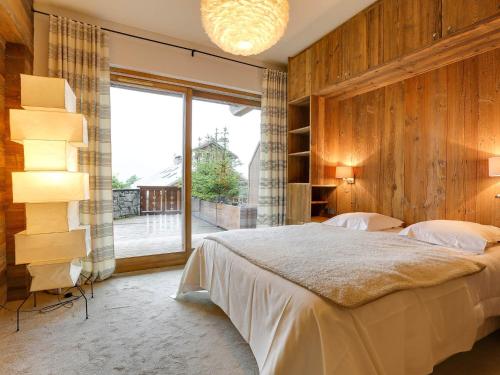 a bedroom with a large bed and a large window at Appartement de Luxe 12 Pers. à 50m des Pistes, Spa, et Cheminée - Méribel - FR-1-565-7 in Les Allues