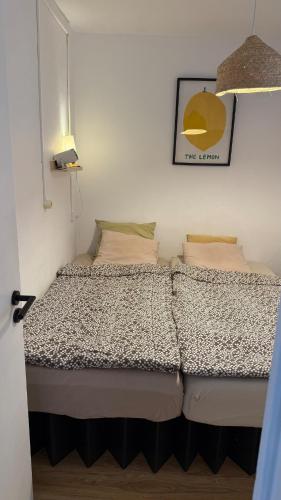 a bed in a small room with a yellow lamp at Lemon and avocado house in Portimão