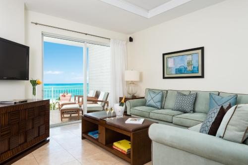 a living room with a couch and a television at West Bay Club in Grace Bay