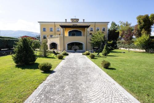 a stone path leading to a large house at La Dimora del Baco Hotel in LʼAquila