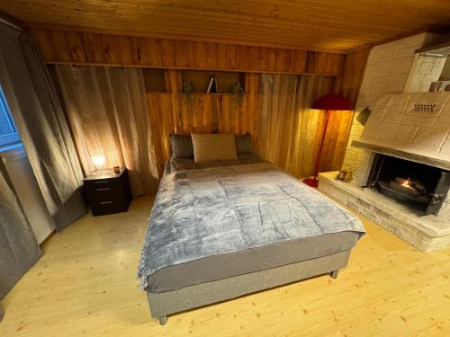 una camera con un grande letto e un camino di Just Like Home Bed & Spa Porsgrunn a Porsgrunn