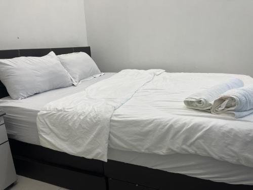 a white bed with white sheets and towels on it at 3A HOMESTAY USTAZ Krai in Kuala Kerai