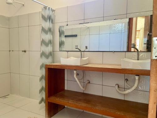 a bathroom with two sinks and a mirror at Casa Sol e mar in Porto Seguro