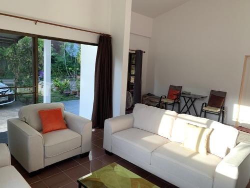 a living room with two white couches and a orange pillow at Spacious 2-bedroom villa near beach in Ban Krut