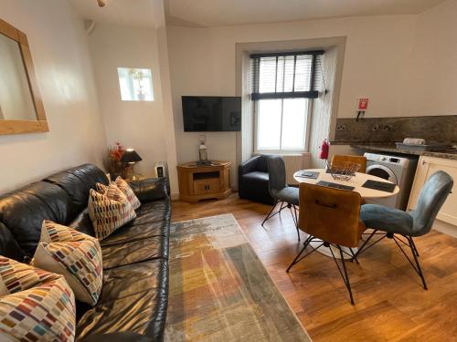 a living room with a couch and a table at Auld Leigh-Lann Apartments in Anstruther