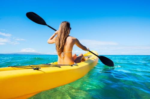 a woman in a yellow kayak in the ocean at Lady Butterfly in Tučepi