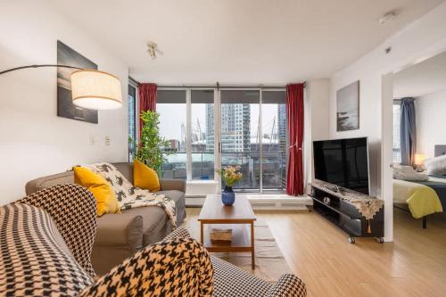 a living room with a couch and a television at Stylish Vancouver Condo with City Views in Vancouver