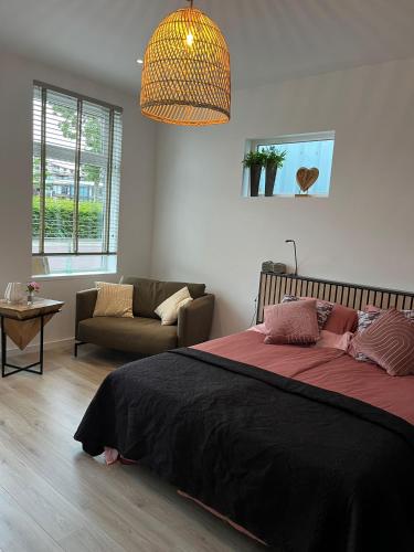 ein Schlafzimmer mit einem großen Bett und einer Couch in der Unterkunft Schie2Be in Schiedam