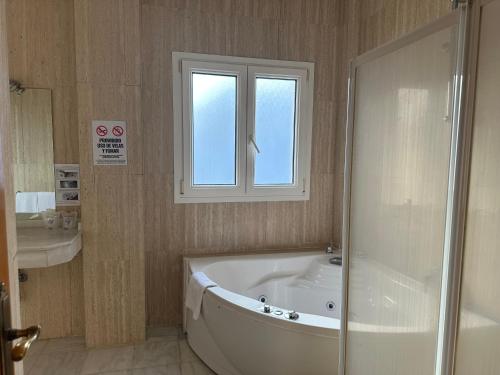a bathroom with a bath tub and a window at La Luna Blanca in Torremolinos