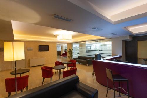 a lobby with a couch and chairs and a bar at La Dimora del Baco Hotel in LʼAquila