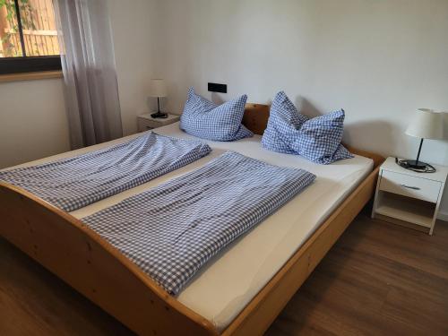 a bed with blue and white pillows on it at Ferienwohnung Familie Roth in Rückholz