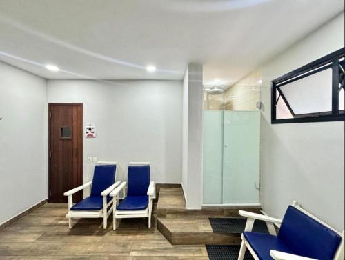 a waiting room with blue chairs and a glass door at Flat Fortune Jardins in Sao Paulo