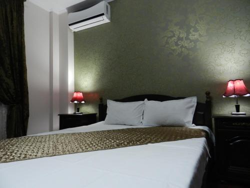 ブカレストにあるHotel Mariniiのベッドルーム(白いベッド1台、ランプ2つ付)