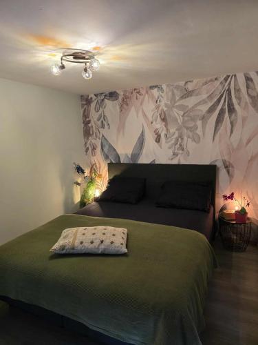 a bedroom with a bed with a green blanket on it at Ardennen Le Chalet Castor - Bomal - Durbuy in Bomal