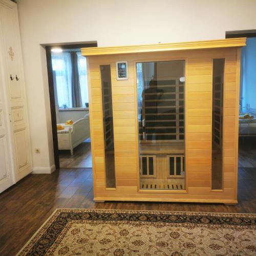 a room with a large wooden cabinet in a living room at Kúria apartman with private jacuzzi and pool in Budapest