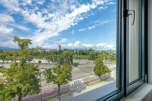 a window with a view of a street and trees at Moxy Verona in Verona