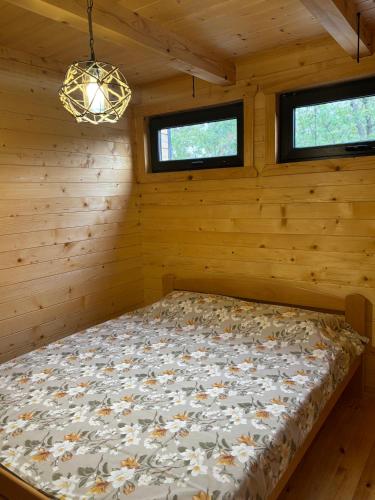 a bedroom with a bed in a log cabin at Driftwood Dreams in Cetinje