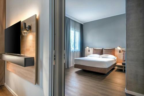a hotel room with a bed and a television at Moxy Verona in Verona