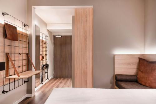 a bedroom with a bed and a chair in a room at Moxy Verona in Verona