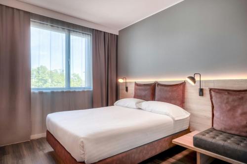 a bedroom with a large bed and a window at Moxy Verona in Verona