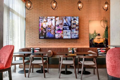 a restaurant with tables and chairs and a tv on a brick wall at Moxy Verona in Verona