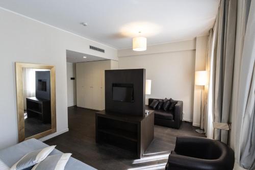 a living room with a couch and a television at La Dimora del Baco Hotel in LʼAquila