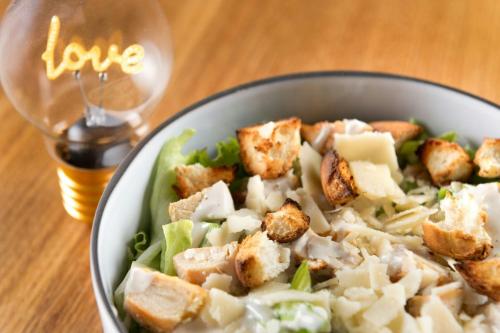 a bowl of food on a table with a glass of wine at Moxy Verona in Verona