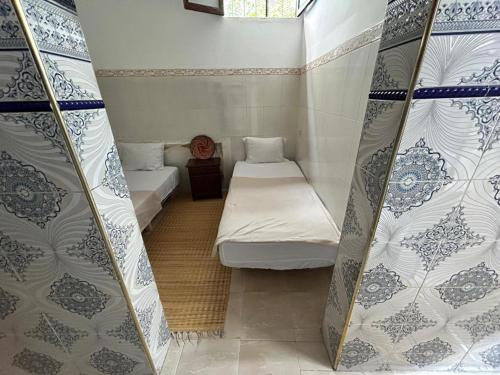a small room with two beds in a room at Miramar GuestHouse in Taghazout