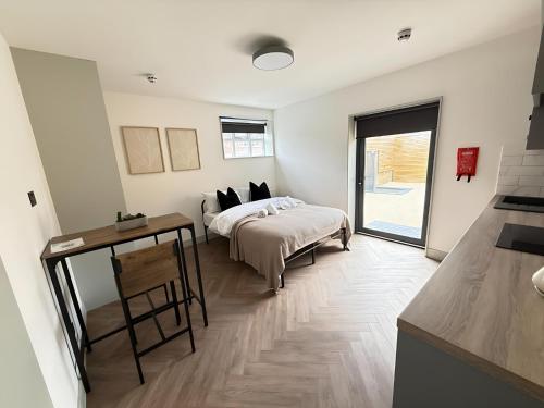 a bedroom with a bed and a table and a window at City Luxe Garden Suite in Crystal Palace