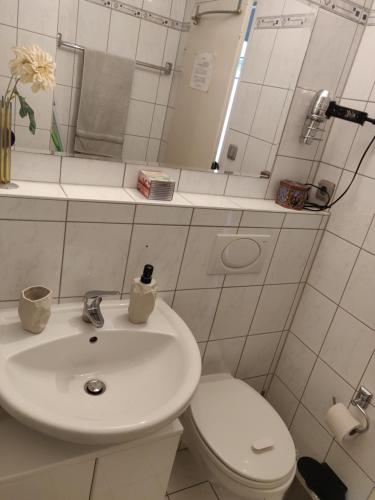a bathroom with a white sink and a toilet at Schönes, zentral gelegenes Zimmer mit Südbalkon in Munich