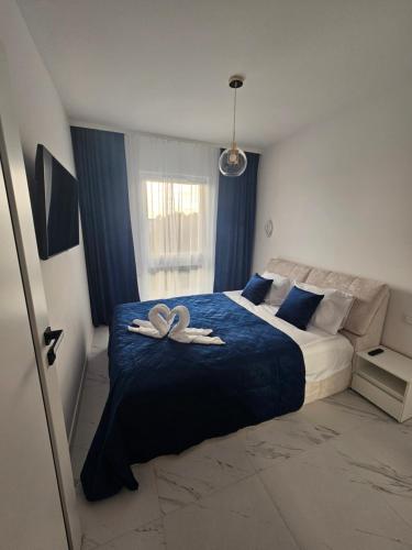 une chambre avec un lit avec deux serviettes blanches dessus dans l'établissement Apartamenty Szafir Let's Sea Gąski, à Gąski