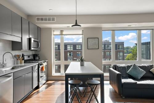 a kitchen and living room with a couch and a table at CozySuites Marquee in Minneapolis