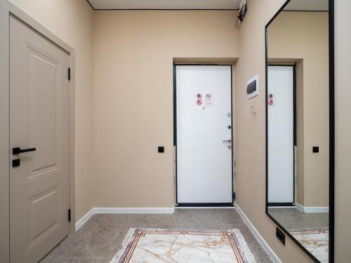 a hallway with two doors and a mirror at Комфортная евродвушка у проспекта Абая, рядом с метро in Almaty