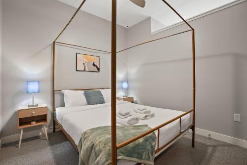 een slaapkamer met een hemelbed en een nachtkastje bij CozySuites Marquee in Minneapolis