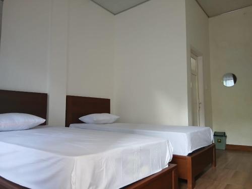 a bedroom with a large bed with white sheets at Pandava House Lombok in Lombok International Airport