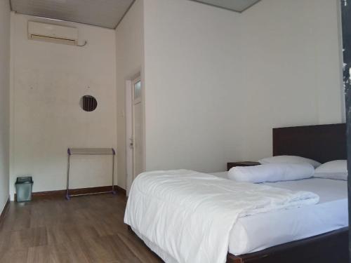 a bedroom with a large bed with white sheets at Pandava House Lombok in Lombok International Airport