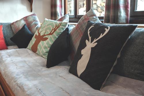 a couch with pillows on top of it with at Chalet Jora - Total Chalets in Bansko